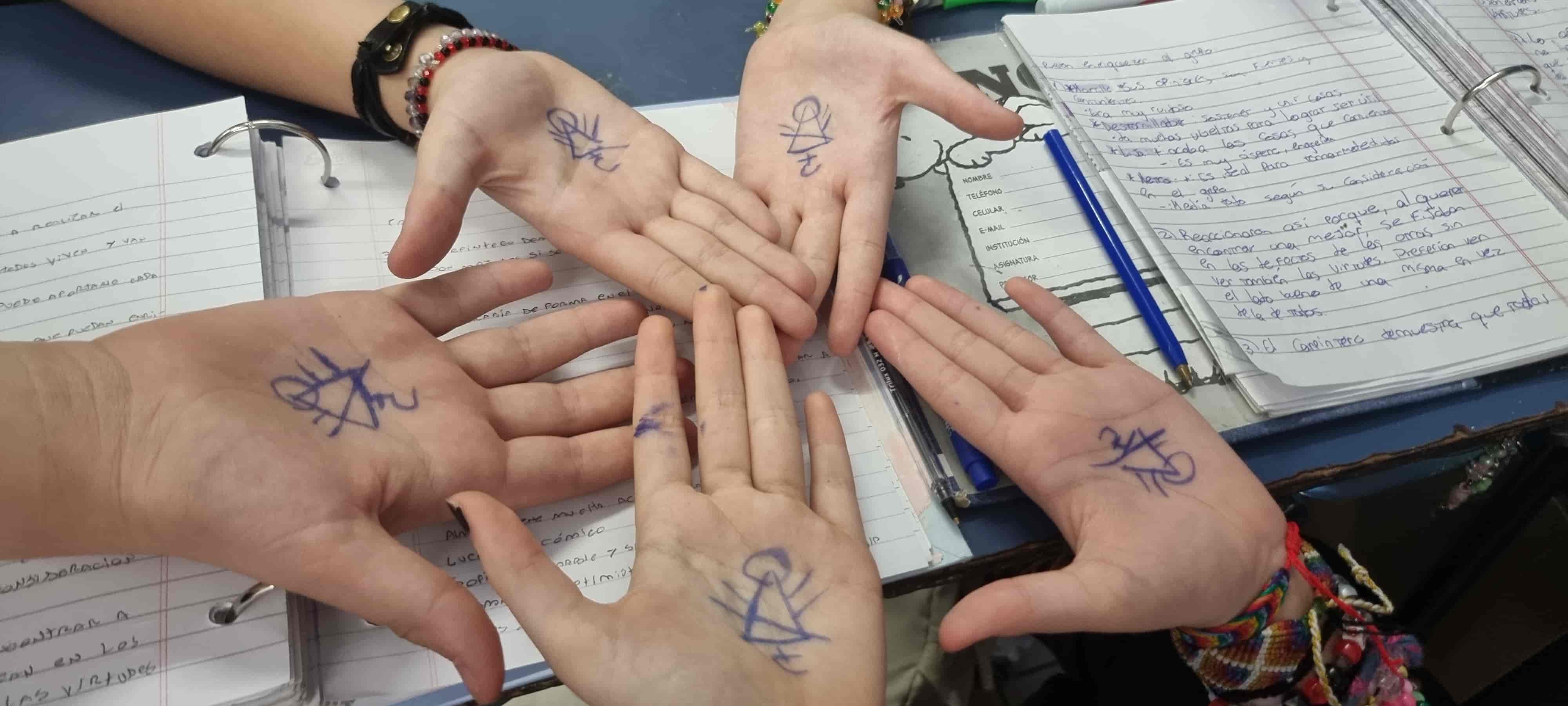 las manos de mis amigas con el simbolo de yellowjackets escrito